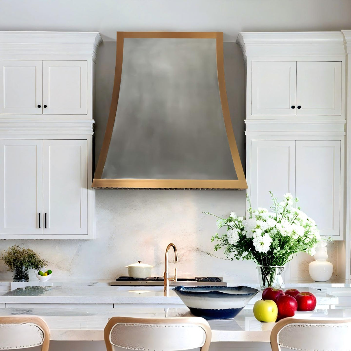 Modern kitchen with white cabinets, a range hood, and decorative elements.