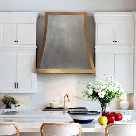 Modern kitchen with white cabinets, a range hood, and decorative elements.