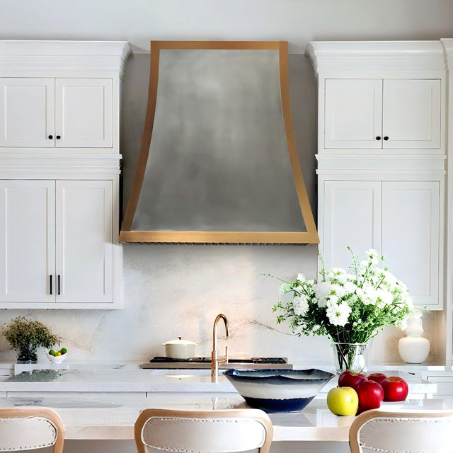 Modern kitchen with white cabinets, a range hood, and decorative elements.
